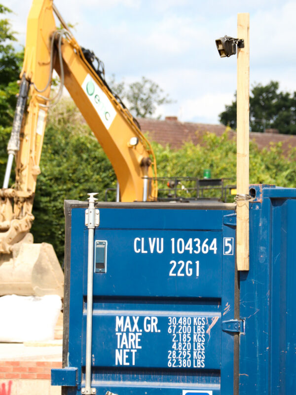 Construction site with an excavator and container. Reconeyez detector mounted on the container.